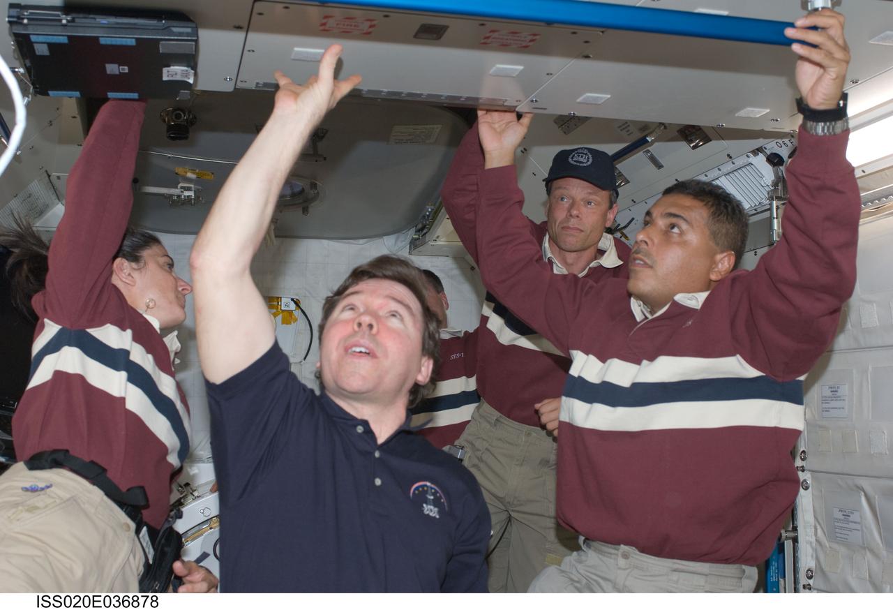 ISS020-E-036878 (30 Aug. 2009) ---  This is one of a series of digital still images that were recorded shortly after the STS-128 and Expedition 20 crewmembers reunited in space and not long after the Space Shuttle Discovery and the International Space Station joined up in Earth orbit to create the second consecutive 13-person aggregation to  perform more work on the orbital outpost.  From the left are astronauts Nicole Stott, STS-128 mission specialist, soon to transfer into a role as Expedition 20 flight engineer, and Michael Barratt, Expedition 20 flight engineer, along with European Space Agency astronaut Christer Fugelsang, STS-128 mission specialist.