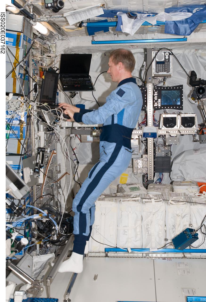 ISS020-E-037162 (30 Aug. 2009) --- European Space Agency astronaut Frank De Winne, Expedition 20 flight engineer, uses a computer in the Columbus laboratory of the International Space Station while Space Shuttle Discovery (STS-128) remains docked with the station.