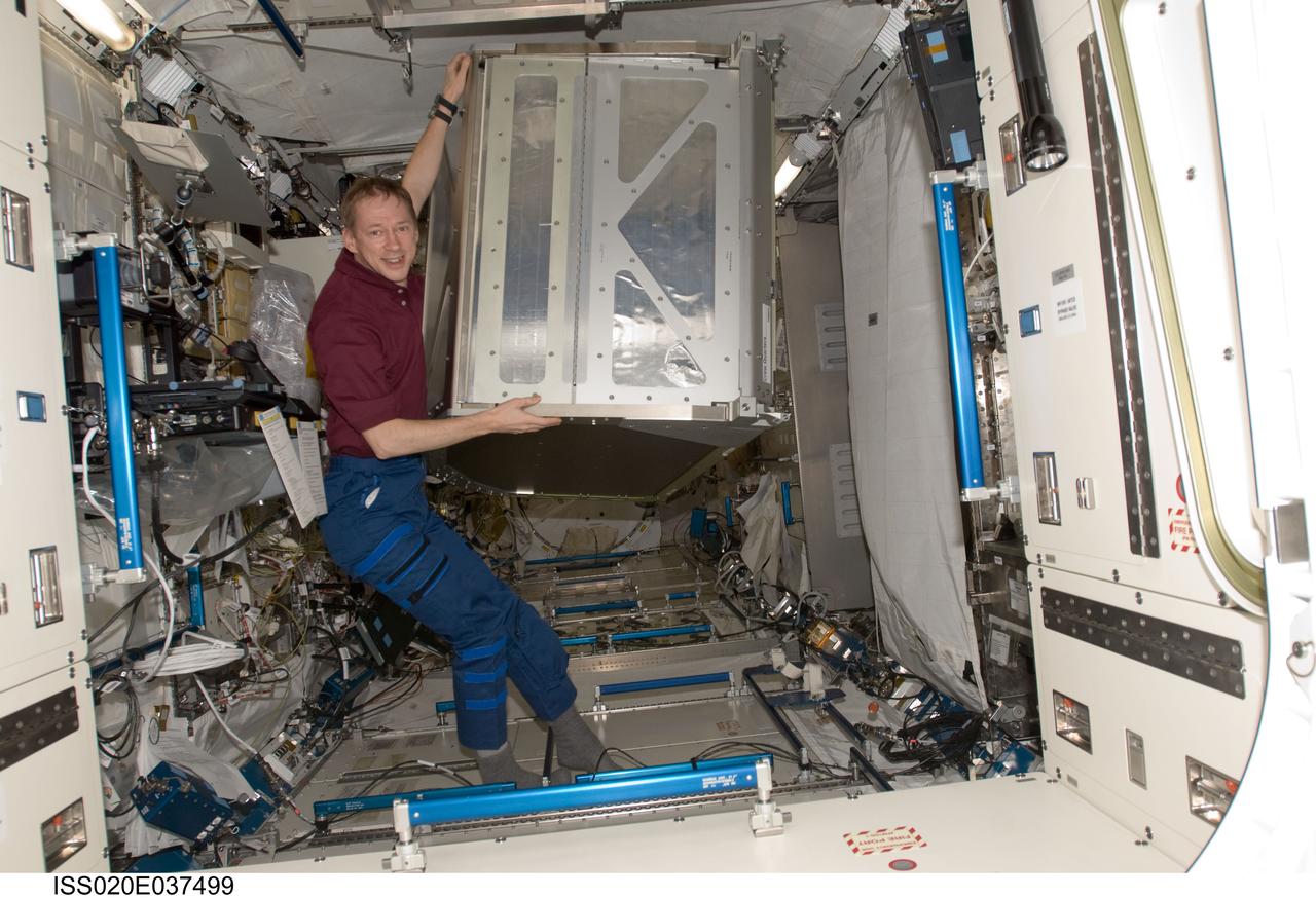 ISS020-E-037499 (1 Sept. 2009) --- European Space Agency astronaut Frank De Winne, Expedition 20 flight engineer, prepares to install a new crew quarters compartment in the Kibo laboratory of the International Space Station while Space Shuttle Discovery (STS-128) remains docked with the station.
