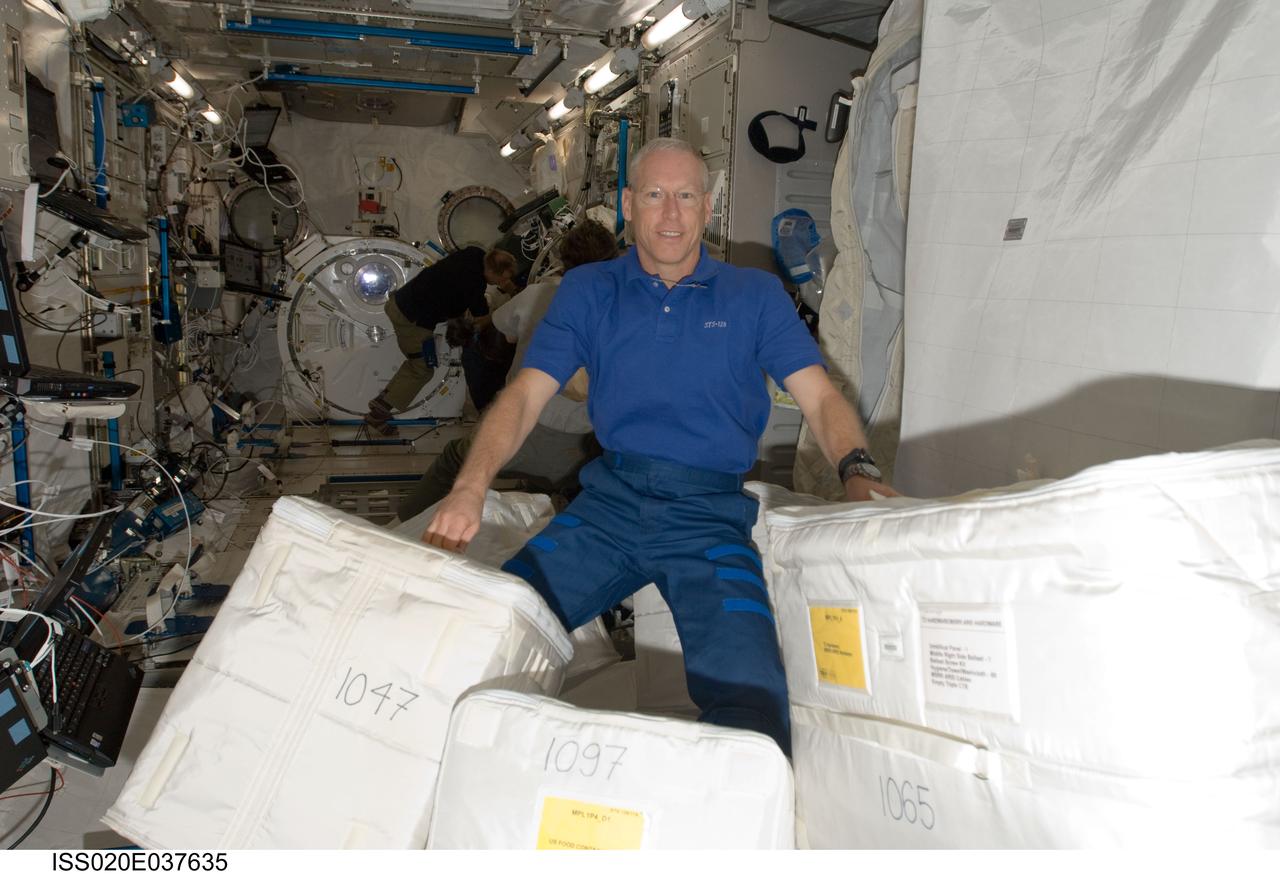 ISS020-E-037635 (31 Aug. 2009) --- Astronaut Patrick Forrester, STS-128 mission specialist, moves cargo containers in the Kibo laboratory of the International Space Station while Space Shuttle Discovery remains docked with the station.