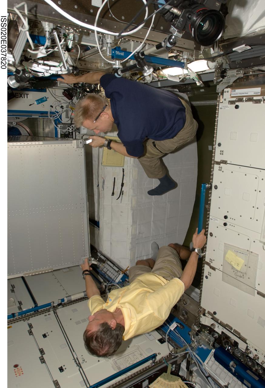 ISS020-E-037820 (2 Sept. 2009) --- European Space Agency astronaut Christer Fuglesang (bottom) and NASA astronaut Tim Kopra, both STS-128 mission specialists, install a new Minus Eighty Degree Laboratory Freezer for ISS (MELFI) rack in the Destiny laboratory of the International Space Station.