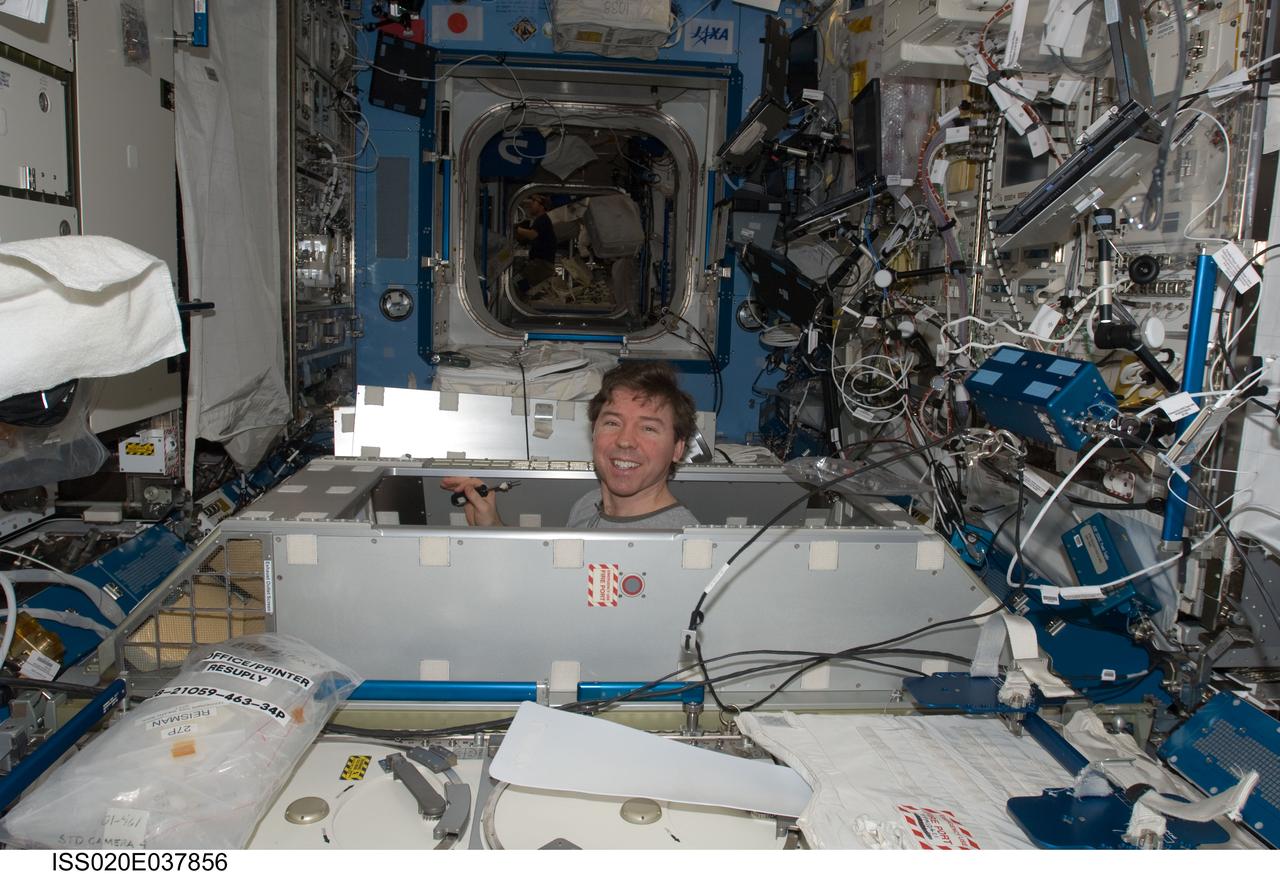 ISS020-E-037856 (2 Sept. 2009) --- NASA astronaut Michael Barratt, Expedition 20 flight engineer, works in the Kibo laboratory of the International Space Station while Space Shuttle Discovery (STS-128) remains docked with the station.