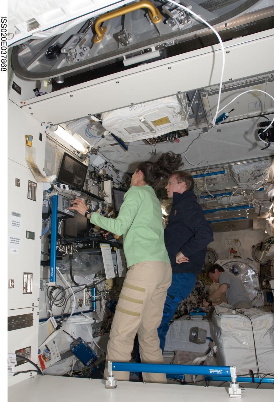 ISS020-E-037868 (2 Sept. 2009) --- NASA astronaut Nicole Stott and European Space Agency astronaut Frank De Winne, both Expedition 20 flight engineers, work at the Japanese Remote Manipulator System (JEM-RMS) work station in the Kibo laboratory of the International Space Station while Space Shuttle Discovery remains docked with the station.