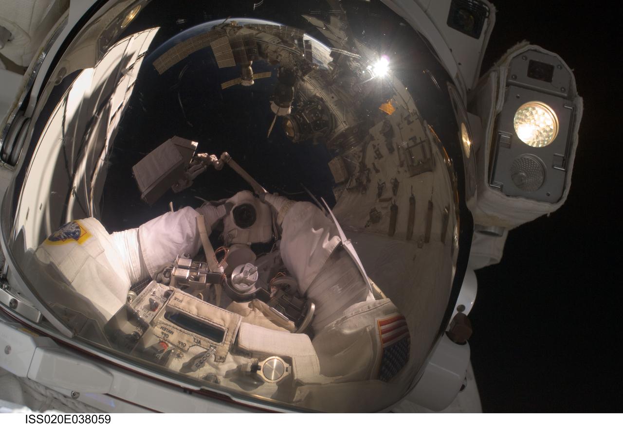 ISS020-E-038059 (3 Sept. 2009) --- NASA astronaut John ?Danny? Olivas, STS-128 mission specialist, uses a digital still camera to expose a photo of his helmet visor during the mission?s second session of extravehicular activity (EVA) as construction and maintenance continue on the International Space Station. Also visible in the reflections in the visor are various components of the station and European Space Agency astronaut Christer Fuglesang, mission specialist, anchored to a Canadarm2 mobile foot restraint. During the six-hour, 39-minute spacewalk, Olivas and Fuglesang installed the new Ammonia Tank Assembly on the Port 1 Truss and stowed the empty tank assembly into the Space Shuttle Discovery?s cargo bay.