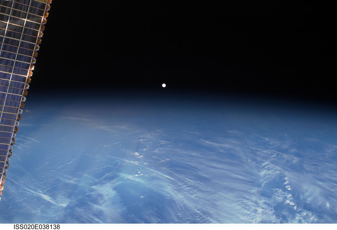 ISS020-E-038138 (3 Sept. 2009) --- A full moon is visible in this view above Earth?s horizon, photographed by a crew member from the International Space Station while Space Shuttle Discovery (STS-128) remains docked with the station. A portion of a station solar array wing is at left.