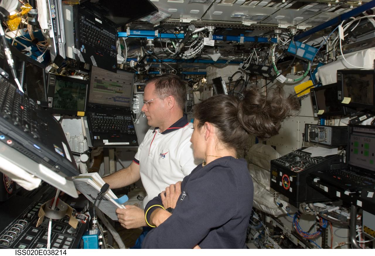 ISS020-E-038214 (3 Sept. 2009) --- NASA astronauts Kevin Ford, STS-128 pilot; and Nicole Stott, Expedition 20 flight engineer, work in the Destiny laboratory of the International Space Station while Space Shuttle Discovery remains docked with the station.