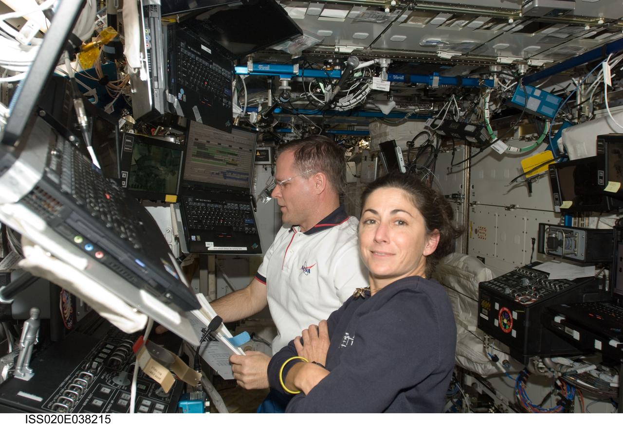 ISS020-E-038215 (3 Sept. 2009) --- NASA astronauts Kevin Ford, STS-128 pilot; and Nicole Stott, Expedition 20 flight engineer, work in the Destiny laboratory of the International Space Station while Space Shuttle Discovery remains docked with the station.
