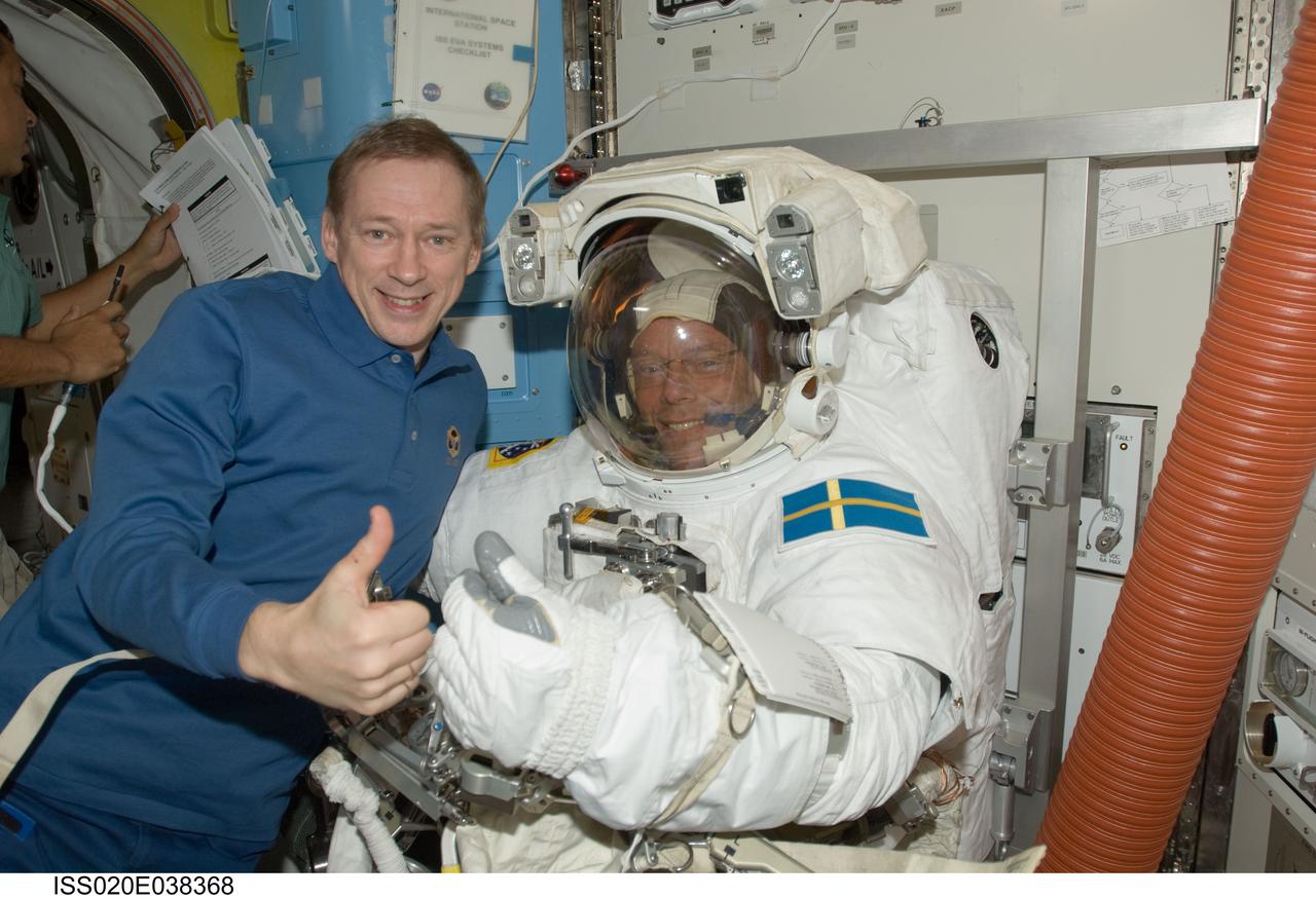 ISS020-E-038368 (3 Sept. 2009) --- European Space Agency astronauts Frank De Winne (left), Expedition 20 flight engineer; and Christer Fuglesang, STS-128 mission specialist, pose for a photo in the Quest airlock of the International Space Station while Space Shuttle Discovery remains docked with the station. Fuglesang is attired in his Extravehicular Mobility Unit (EMU) spacesuit.