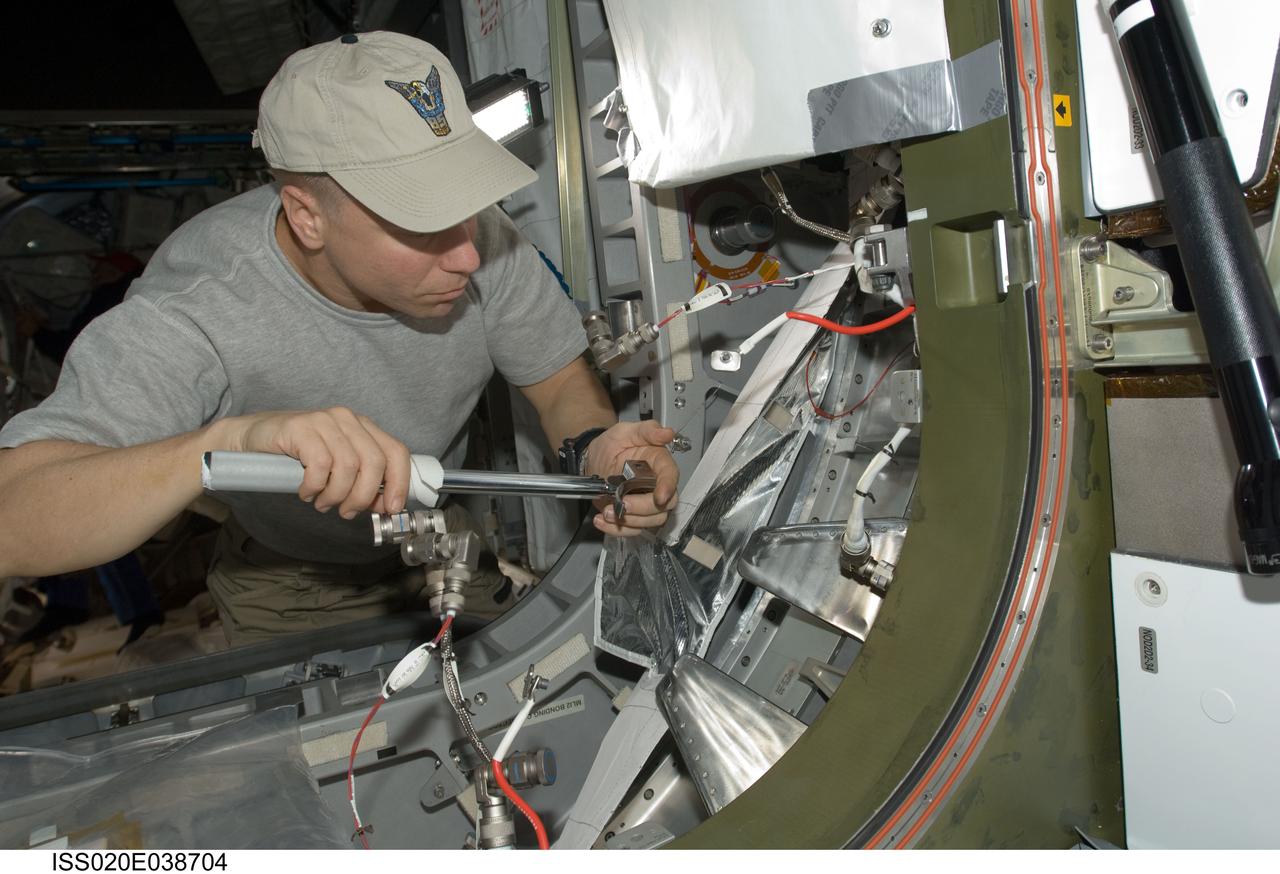 ISS020-E-038704 (5 Sept. 2009) --- NASA astronaut Tim Kopra, STS-128 mission specialist, performs in-flight maintenance (IFM) in a vestibule on the International Space Station while Space Shuttle Discovery remains docked with the station.