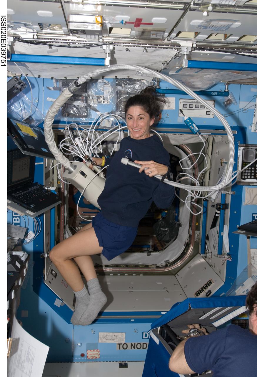 ISS020-E-039751 (12 Sept. 2009) --- NASA astronaut Nicole Stott, Expedition 20 flight engineer, uses a vacuum cleaner in the Destiny laboratory of the International Space Station.