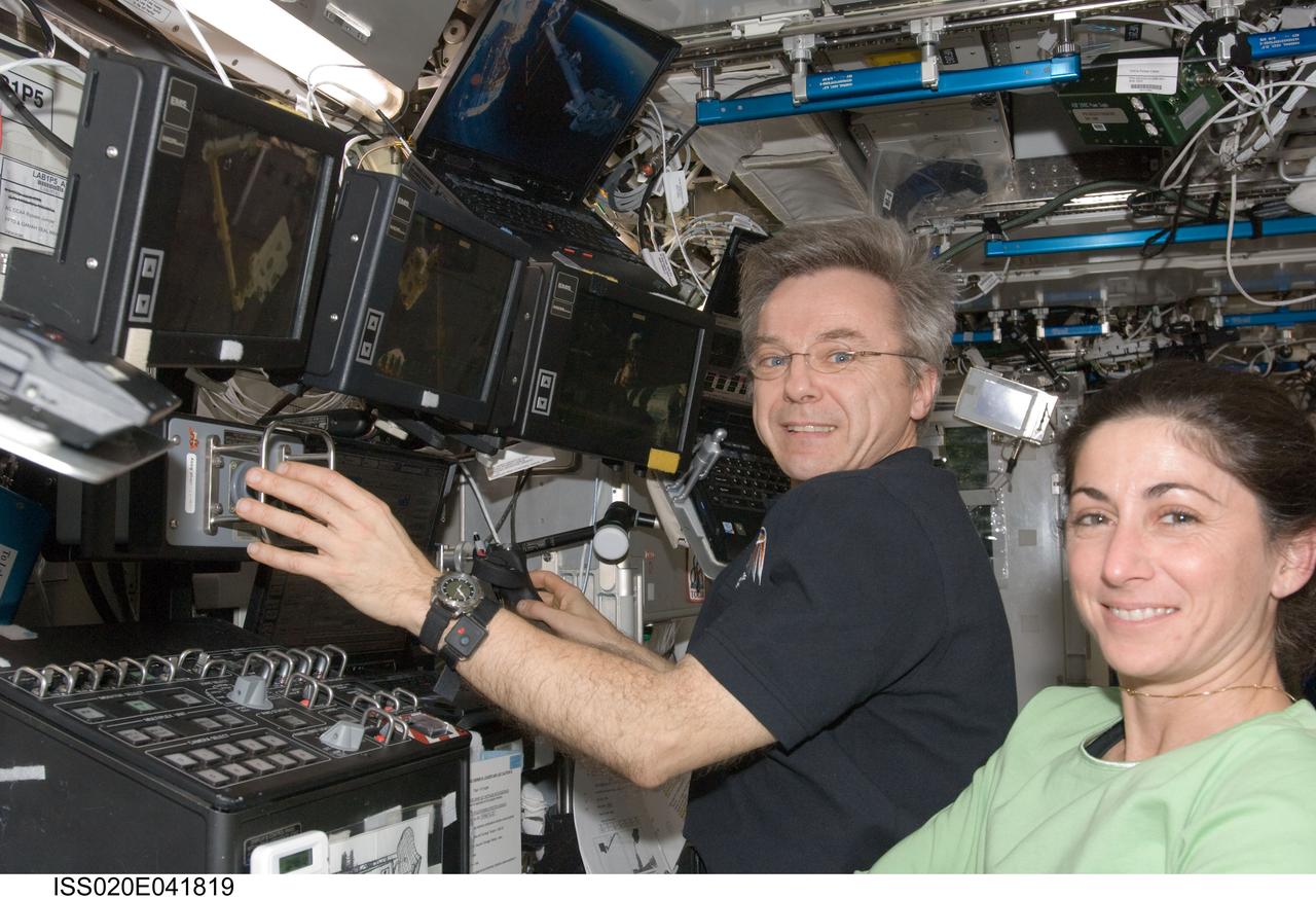 ISS020-E-041819 (23 Sept. 2009) --- Canadian Space Agency astronaut Robert Thirsk and NASA astronaut Nicole Stott, both Expedition 20 flight engineers, work the controls of the Canadarm2 in the Destiny laboratory of the International Space Station. Thirsk and Stott used the station?s robotic arm to release and extract the Exposed Pallet (EP) from the Unpressurized Logistics Carrier (ULC) to hand over to the JEM Robotic Manipulator System (JEM-RMS) and berth to the JEM Exposed Facility / Exposed Facility Unit 10 (JEF EFU10).