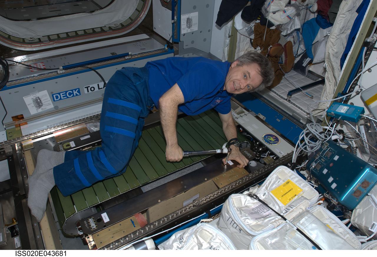 ISS020-E-043681 (30 Sept. 2009) --- Canadian Space Agency astronaut Robert Thirsk, Expedition 20 flight engineer, assembles and installs the Combined Operational Load Bearing External Resistance Treadmill (COLBERT) in its temporary place in the Harmony node of the International Space Station.