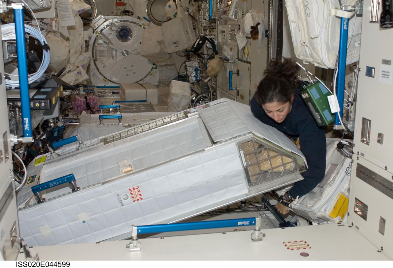 ISS020-E-044599 (30 Sept. 2009) --- NASA astronaut Nicole Stott, Expedition 20 flight engineer, works with her crew quarters compartment in the Kibo laboratory of the International Space Station.