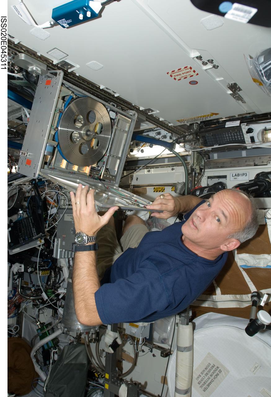 ISS020-E-045311 (5 Oct. 2009) --- NASA astronaut Jeffrey Williams, Expedition 21 flight engineer, performs in-flight maintenance (IFM) on the Cycle Ergometer with Vibration Isolation (CEVIS) braking band in the Destiny laboratory of the International Space Station.