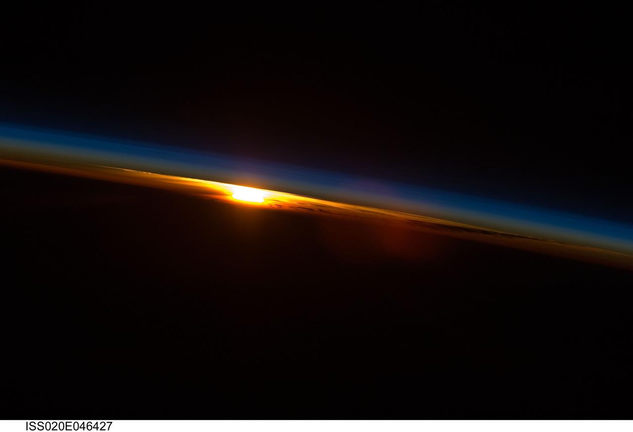 iss020e046427 (Oct. 4, 2009) --- The sun sets below Earth's horizon illuminating the atmosphere with its last rays in this photograph from the International Space Station as it orbited 216 miles above near the Indian Ocean coast of South Africa.