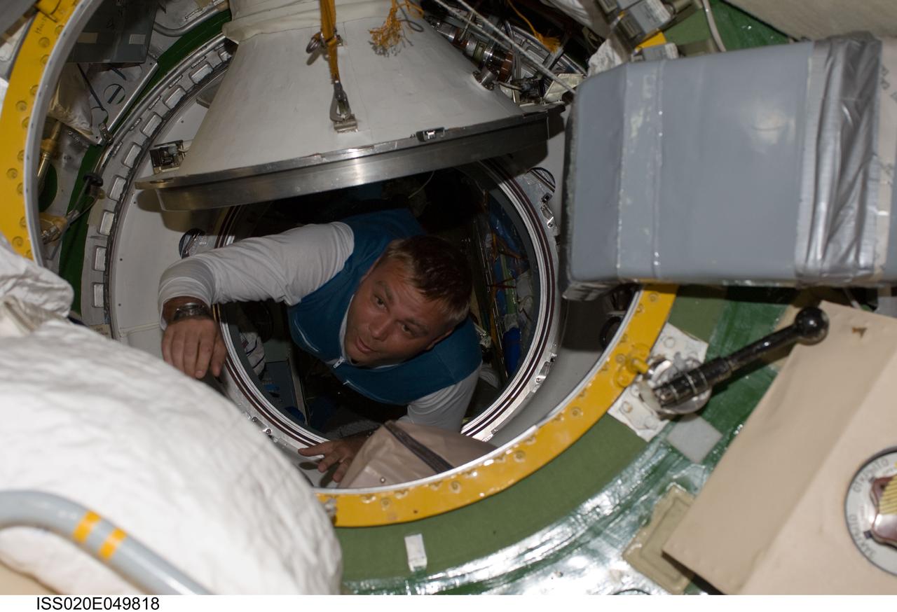 ISS020-E-049818 (2 Oct. 2009) --- Russian cosmonaut Maxim Suraev, Expedition 21/22 flight engineer, ingresses the International Space Station after arriving onboard a Soyuz spacecraft with NASA astronaut Jeffrey Williams, Expedition 21 flight engineer and spaceflight participant Guy Laliberte (both out of frame).