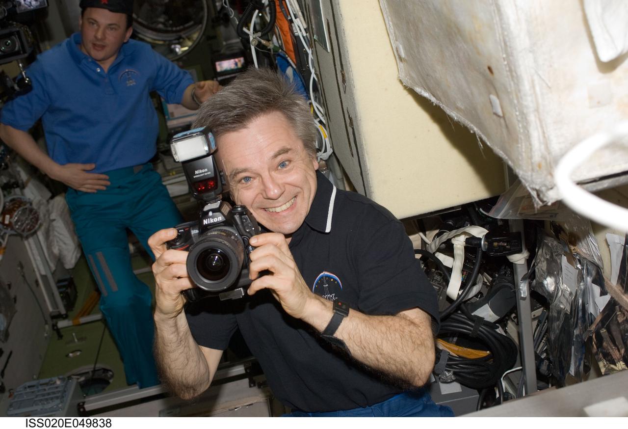 ISS020-E-049838 (2 Oct. 2009) --- Canadian Space Agency astronaut Robert Thirsk, Expedition 20/21 flight engineer, uses a still camera in the Zvezda Service Module of the International Space Station.