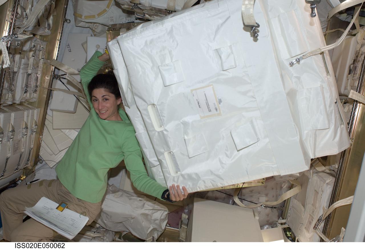 ISS020-E-050062 (4 Oct. 2009) --- NASA astronaut Nicole Stott, Expedition 20/21 flight engineer, moves a stowage container in the Japanese H-II Transfer Vehicle (HTV) docked to the Harmony node of the International Space Station.