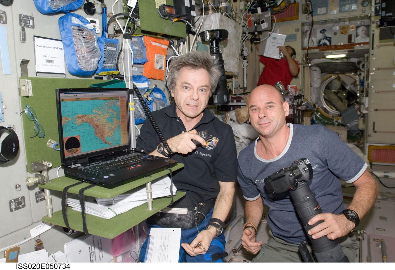 ISS020-E-050734 (9 Oct. 2009) --- Canadian Space Agency astronaut Robert Thirsk (left), Expedition 20/21 flight engineer; and spaceflight participant Guy Laliberte are pictured in the Zvezda Service Module of the International Space Station.
