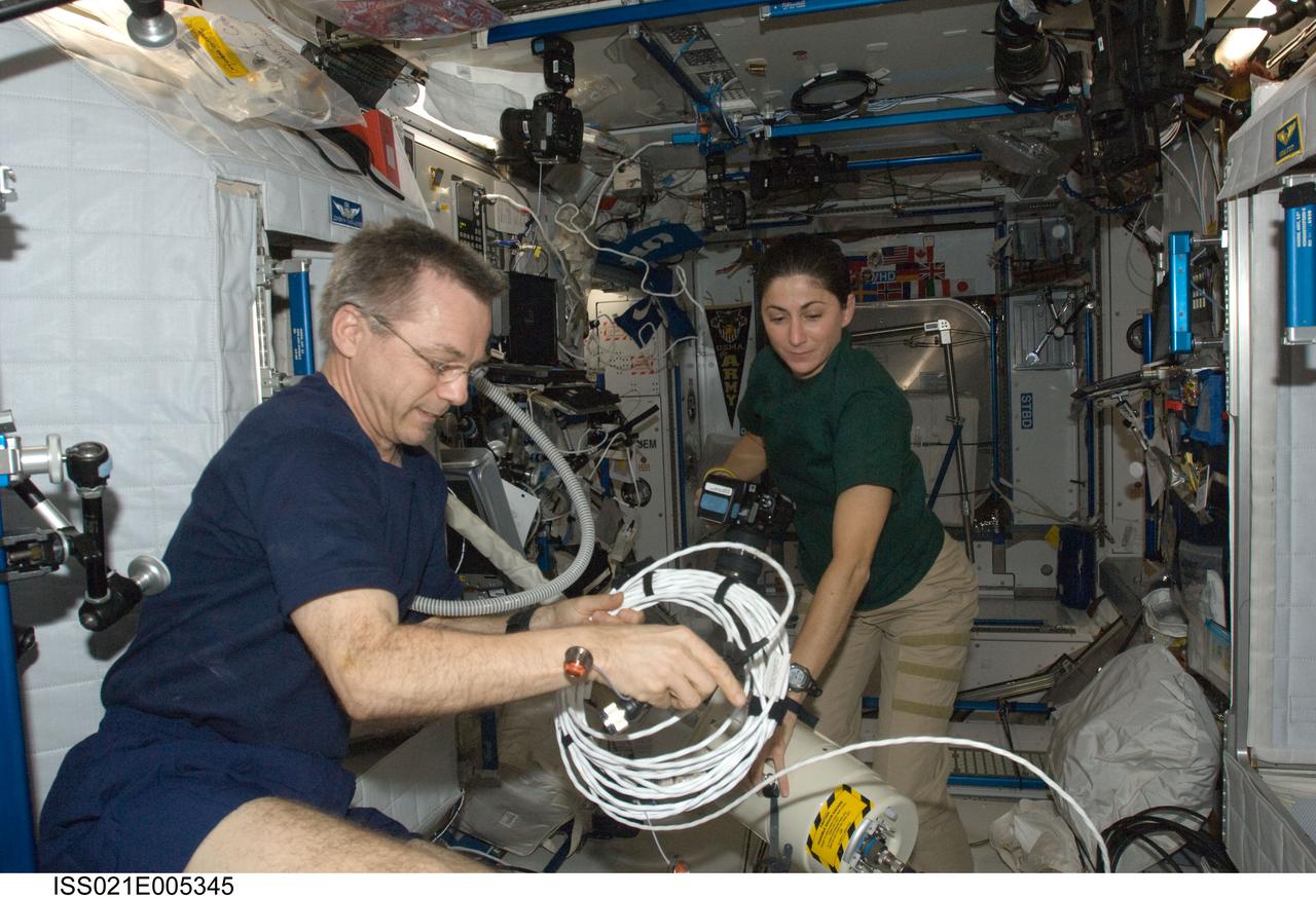 ISS021-E-005345 (11 Oct. 2009) --- Canadian Space Agency astronaut Robert Thirsk and NASA astronaut Nicole Stott, both Expedition 21 flight engineers, work in the Harmony node of the International Space Station.