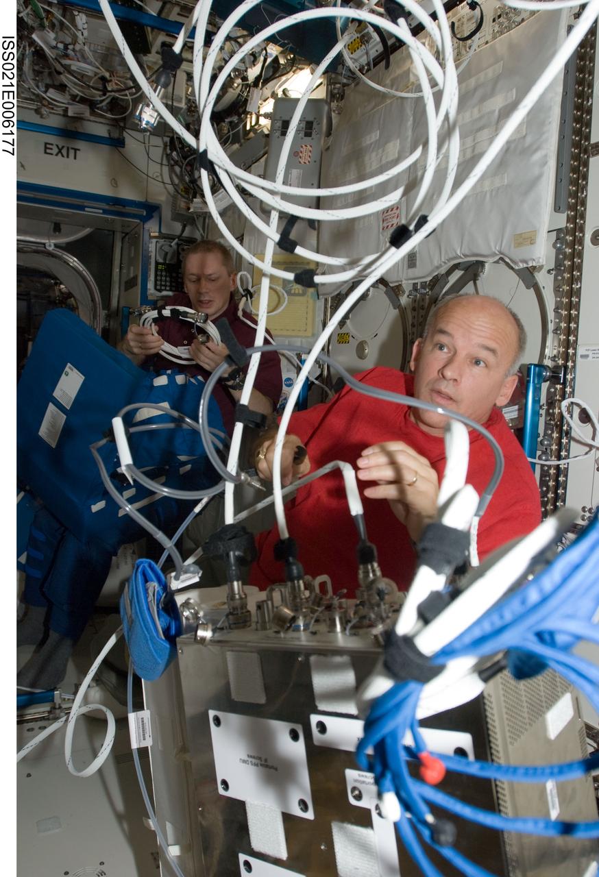 ISS021-E-006177 (14 Oct. 2009) --- NASA astronaut Jeffrey Williams, Expedition 21 flight engineer, works with the Portable Pulmonary Function System (PPFS) in the Destiny laboratory of the International Space Station. European Space Agency astronaut Frank De Winne, commander, works in the background.