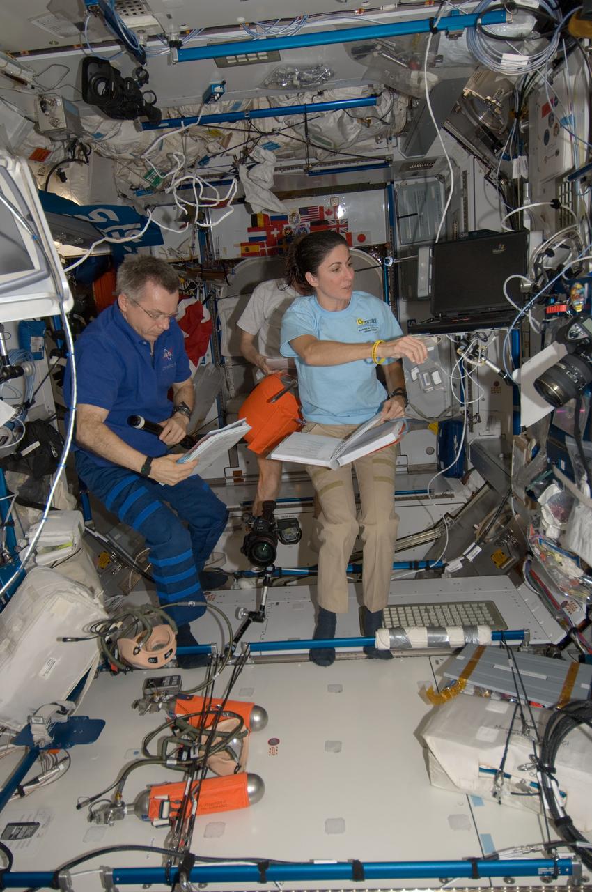 ISS021-E-007030 (15 Oct. 2009) --- Canadian Space Agency astronaut Robert Thirsk and NASA astronaut Nicole Stott, both Expedition 21 flight engineers; along with European Space Agency astronaut Frank De Winne (background), commander, work in the Harmony node of the International Space Station.