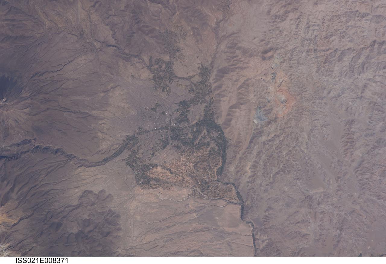 ISS021-E-008371 (16 Oct. 2009) --- The city of Arequipa, Peru is featured in this image photographed by an Expedition 21 crew member on the International Space Station. Several Latin American cities have grown up on the flanks of active volcanoes. The city center of Arequipa, Peru lies only 17 kilometers away from the summit of El Misti volcano (partially out of frame at left); the gray urban area is bordered by green agricultural fields. With almost one million residents in 2009, it is the second city of Peru in terms of population. Much of the building stone for Arequipa, known locally as sillar, is quarried from nearby pyroclastic flow deposits that are white in color. Arequipa is known as ?the White City? because of the prevalence of this building material. The Chili River extends northeastwards from the city center, and flows through a canyon (left) between El Misti volcano and Nevado Chachani to the north.