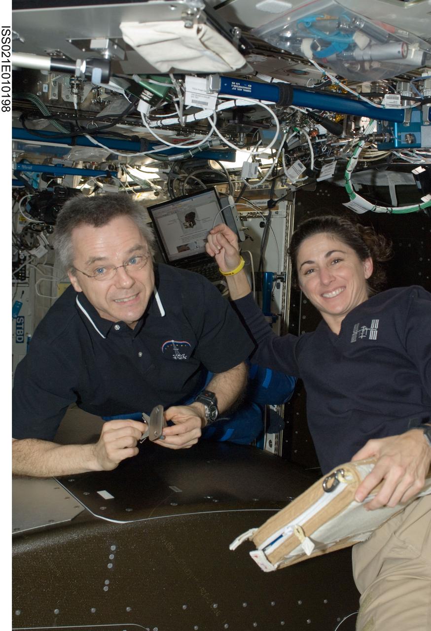 ISS021-E-010198 (19 Oct. 2009) --- Canadian Space Agency astronaut Robert Thirsk and NASA astronaut Nicole Stott, both Expedition 21 flight engineers, install the Active Rack Isolation System (ARIS) hardware on the Fluids Integrated Rack (FIR) in the Destiny laboratory of the International Space Station.