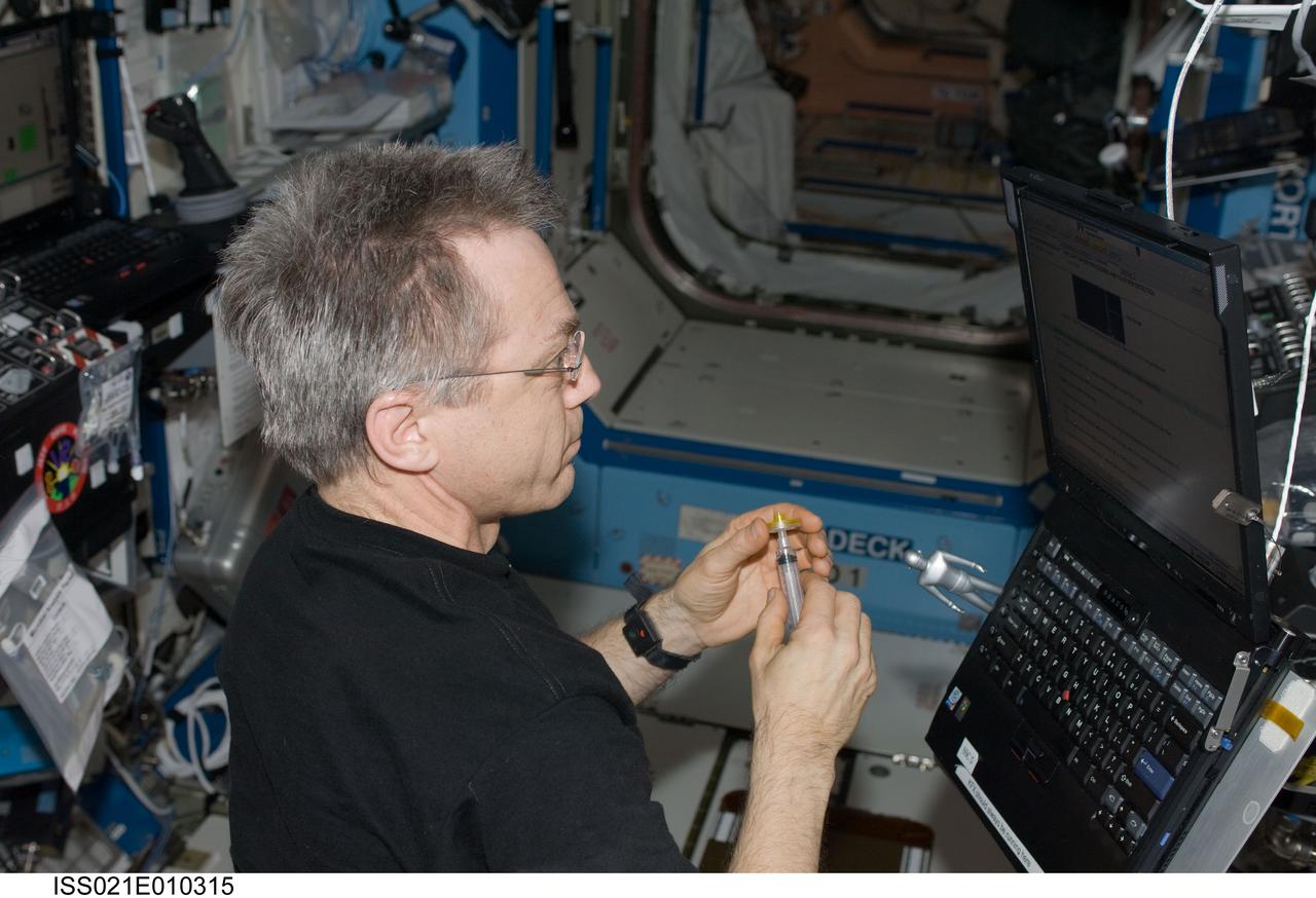 ISS021-E-010315 (20 Oct. 2009) --- Canadian Space Agency astronaut Robert Thirsk, Expedition 21 flight engineer, performs a Potable Water Dispenser (PWD) analysis in the Destiny laboratory of the International Space Station.