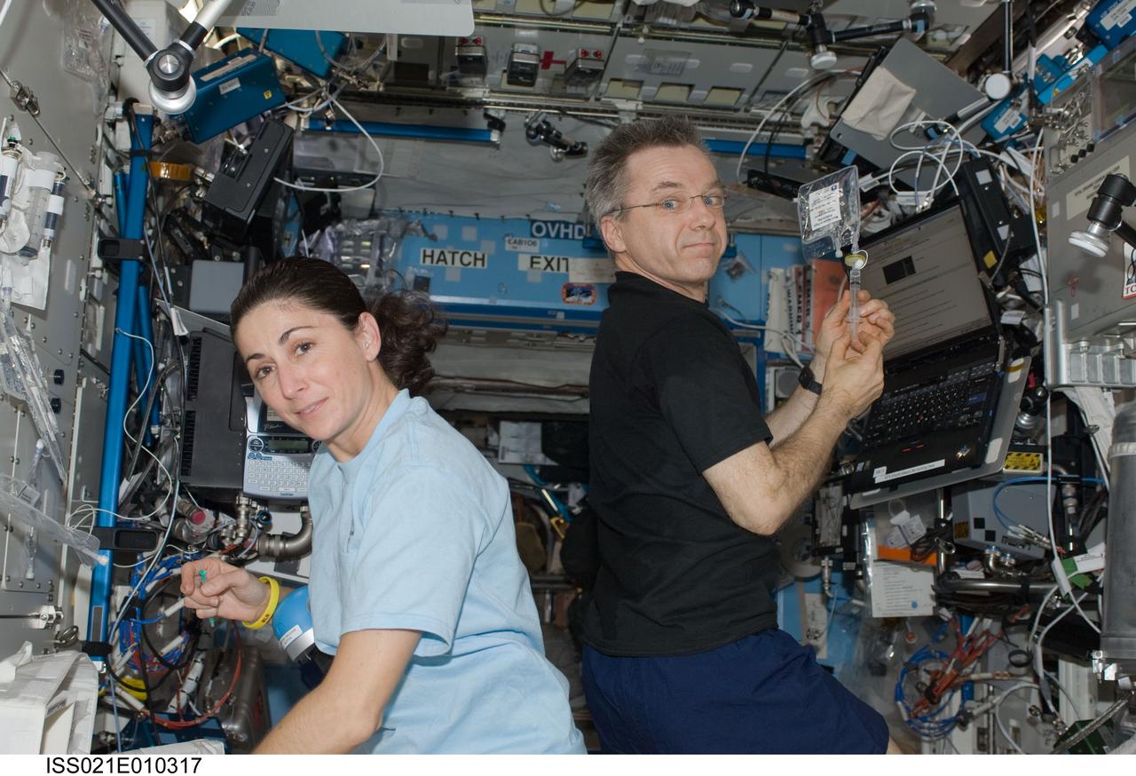 ISS021-E-010317 (20 Oct. 2009) --- NASA astronaut Nicole Stott and Canadian Space Agency astronaut Robert Thirsk, both Expedition 21 flight engineers, perform water analyses in the Destiny laboratory of the International Space Station.