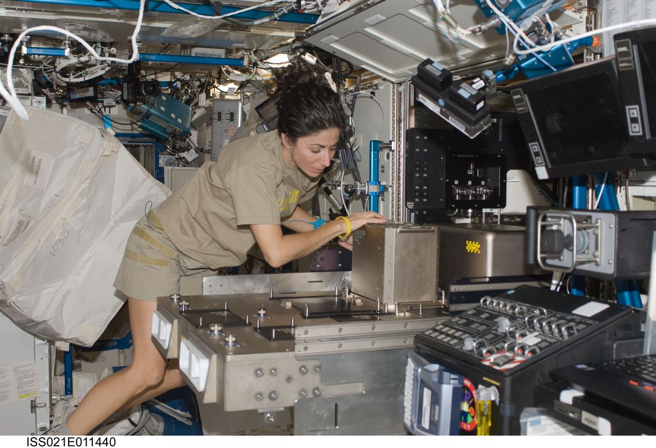 ISS021-E-011440 (22 Oct. 2009) --- NASA astronaut Nicole Stott, Expedition 21 flight engineer, installs hardware in the Fluids Integrated Rack (FIR) in the Destiny laboratory of the International Space Station.