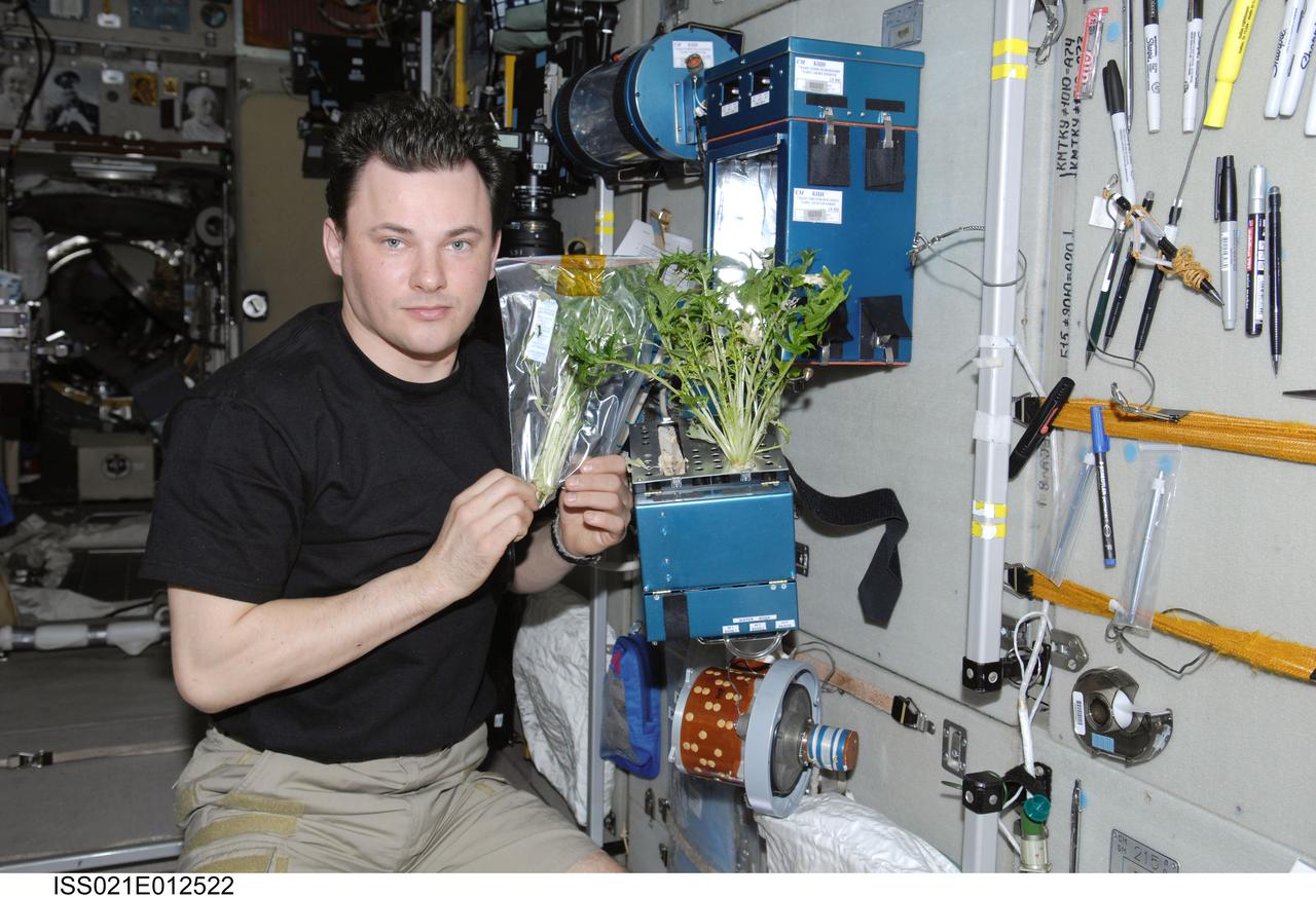 ISS021-E-012522 (26 Oct. 2009) --- Russian cosmonaut Roman Romanenko, Expedition 21 flight engineer, poses for a photo with the current growth experiment on the BIO-5 Rasteniya-2 (Plants-2) payload in the Zvezda Service Module of the International Space Station.