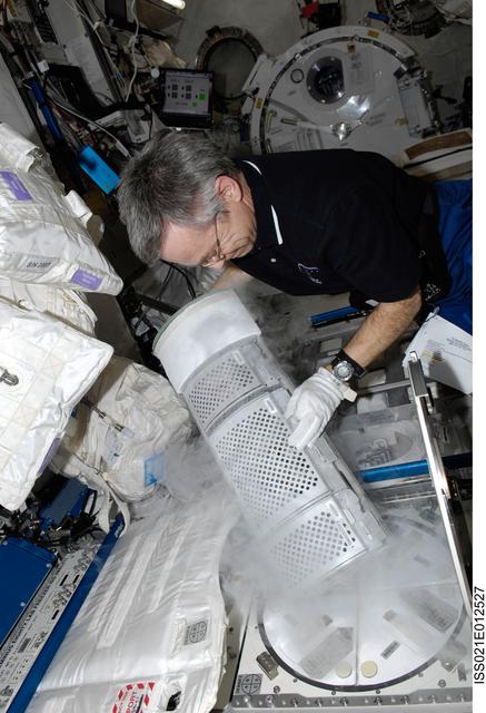 NASA image: FE Thirsk removes a Dewar Tray from the MELFI