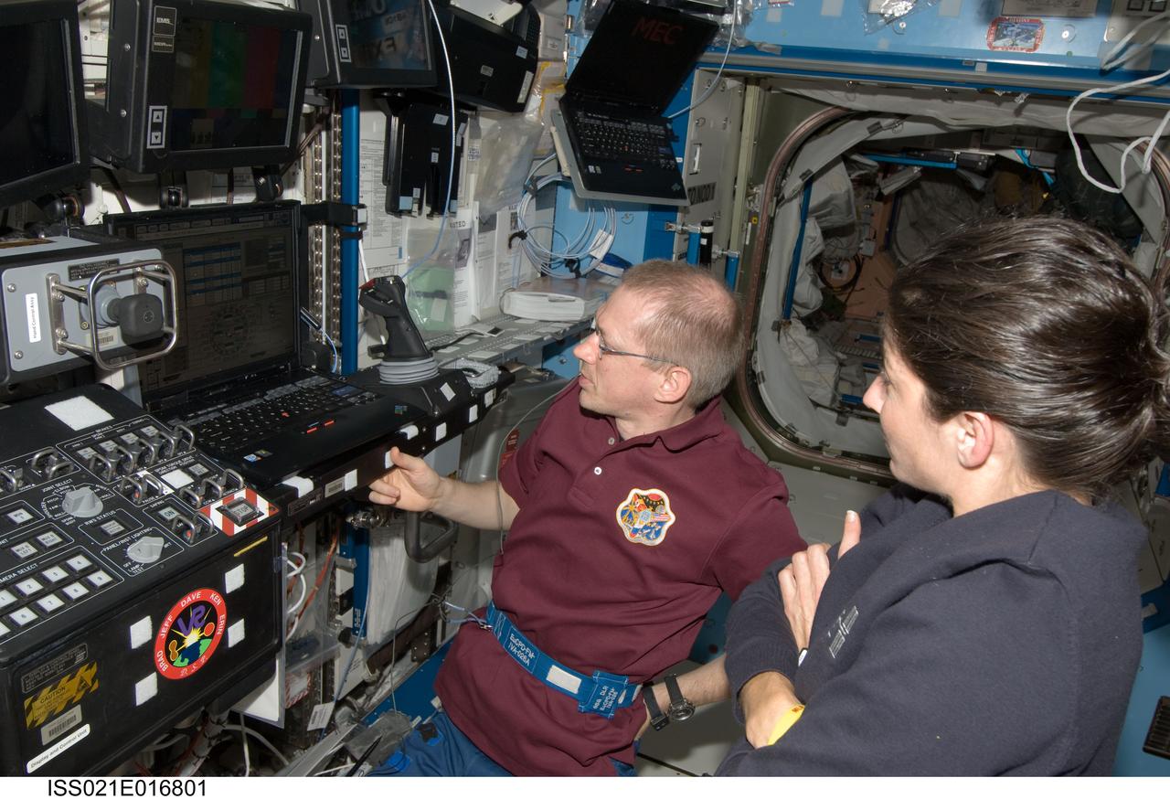 ISS021-E-016801 (30 Oct. 2009) --- European Space Agency astronaut Frank De Winne, Expedition 21 commander; and NASA astronaut Nicole Stott, flight engineer, view computer monitors at the Canadarm2 workstation in the Destiny laboratory of the International Space Station during the preparation for the release of the Japanese H-II Transfer Vehicle (HTV) from the station. De Winne, Stott and Canadian Space Agency astronaut Robert Thirsk (out of frame) used the station’s robotic arm to grab the HTV cargo craft, filled with trash and unneeded items, and unberth it from the Harmony node’s nadir port. The HTV was successfully unberthed at 10:18 a.m. (CDT) on Oct. 30, 2009, and released from the station’s Canadarm2 at 12:32 p.m.