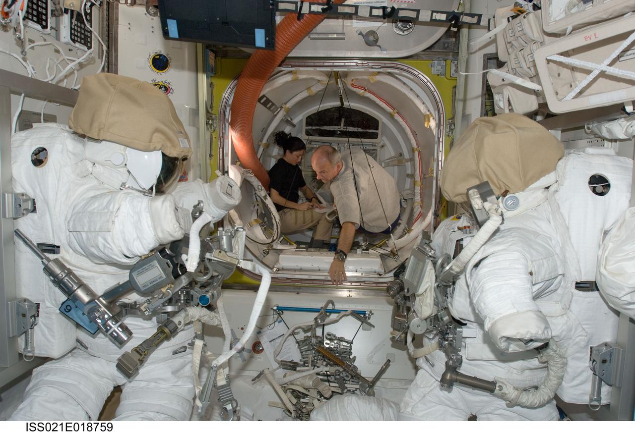 ISS021-E-018759 (2 Nov. 2009) --- NASA astronauts Nicole Stott and Jeffrey Williams, both Expedition 21 flight engineers, work in the Quest airlock of the International Space Station. Two Extravehicular Mobility Unit (EMU) spacesuits are visible in the foreground.