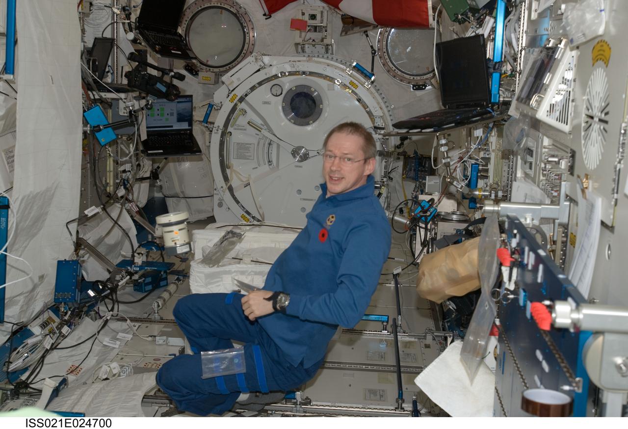 ISS021-E-024700 (11 Nov. 2009) --- European Space Agency astronaut Frank De Winne, Expedition 21 commander, uses the Microbial Air Sampler kit (floating freely near De Winne) to obtain microbiology (bacterial & fungal) air samples in the Kibo laboratory of the International Space Station.