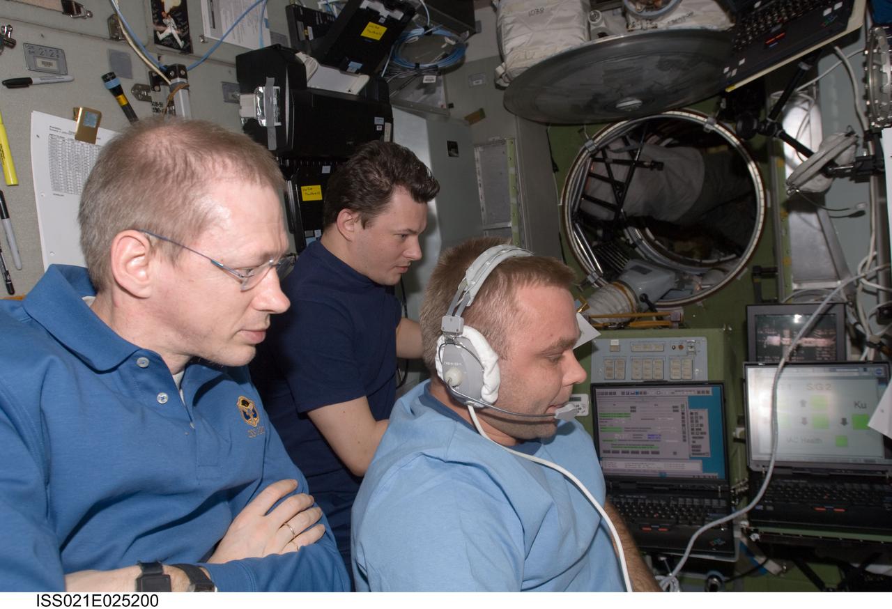 ISS021-E-025200 (12 Nov. 2009) --- European Space Agency astronaut Frank De Winne (left foreground), Expedition 21 commander; along with Russian cosmonauts Maxim Suraev (right) and Roman Romanenko, both flight engineers, are pictured in the Zvezda Service Module of the International Space Station during docking operations of the unpiloted Russian Mini-Research Module 2 (MRM2), also known as Poisk. The MRM2 docked to Zvezda’s space-facing port at 9:41 a.m. (CST) on Nov. 12, 2009.