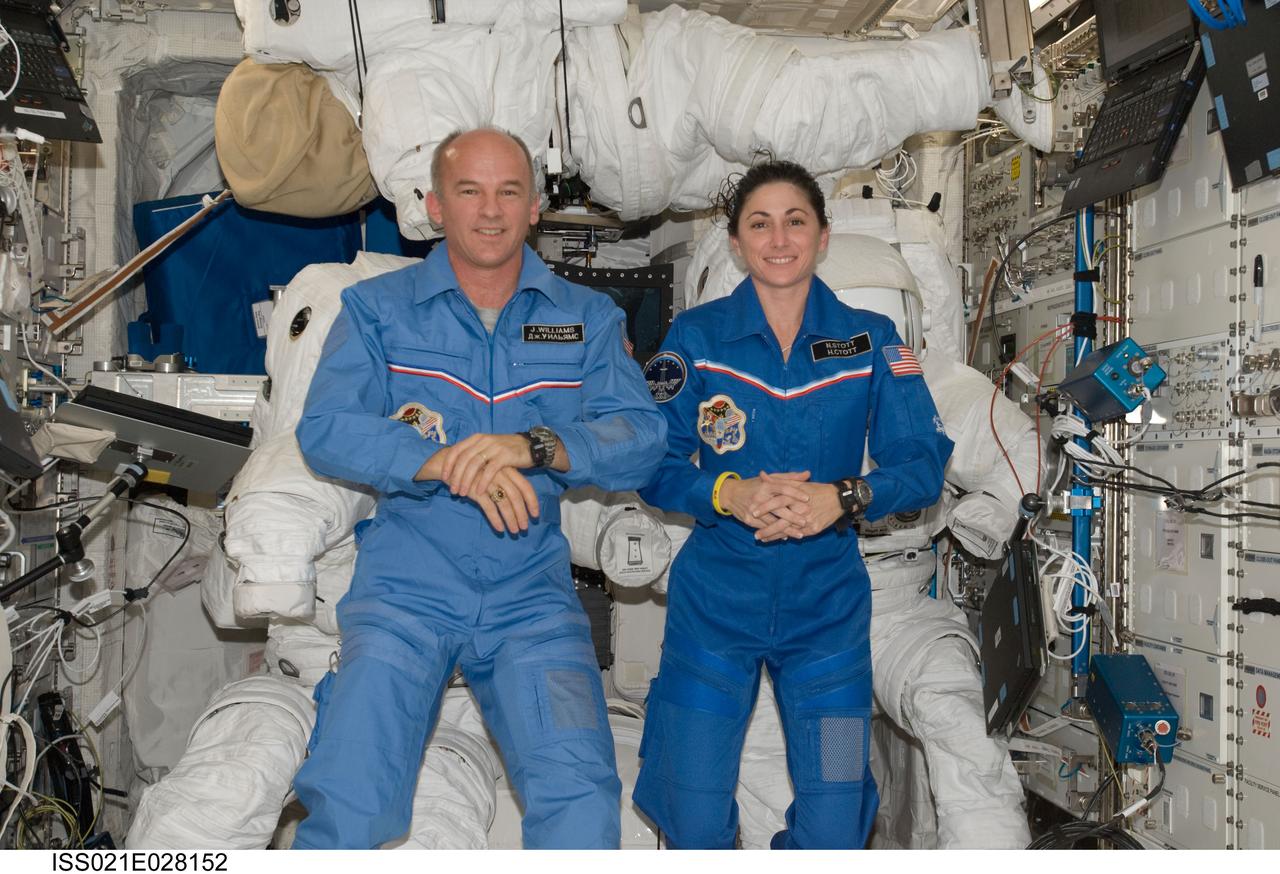 ISS021-E-028152 (17 Nov. 2009) --- NASA astronauts Jeffrey Williams and Nicole Stott, both Expedition 21 flight engineers, pose for a photo with three Extravehicular Mobility Unit (EMU) spacesuits in the Columbus laboratory of the International Space Station.