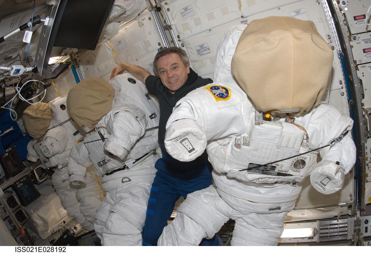 ISS021-E-028192 (17 Nov. 2009) --- Canadian Space Agency astronaut Robert Thirsk, Expedition 21 flight engineer, is pictured with three Extravehicular Mobility Unit (EMU) spacesuits in the Columbus laboratory of the International Space Station.