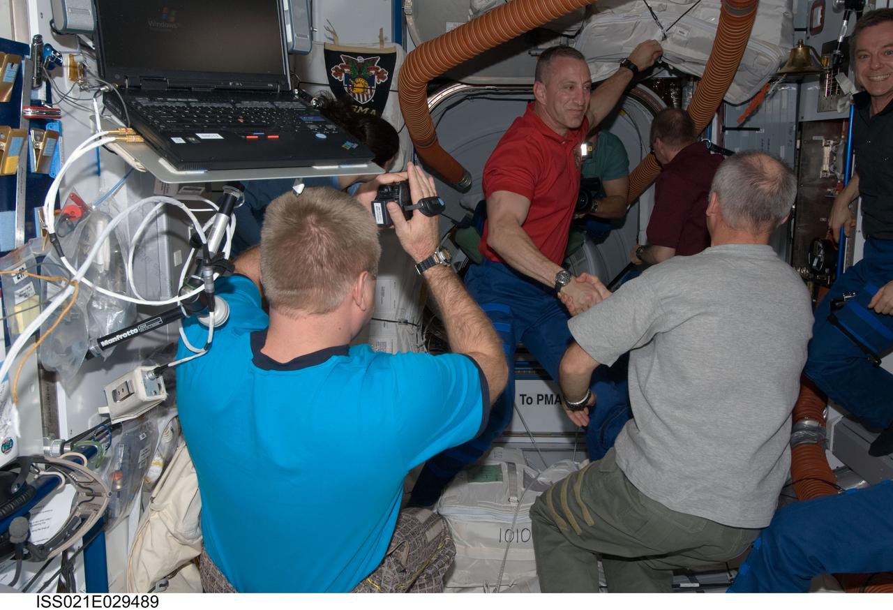 ISS021-E-029489 (18 Nov. 2009) --- STS-129 and Expedition 21 crew members greet each other shortly after Space Shuttle Atlantis and the International Space Station docked in space and the hatches were opened on Nov. 18, 2009. Pictured are NASA astronauts Charles O. Hobaugh (top), STS-129 commander; and Jeffrey Williams (right foreground), Expedition 21 flight engineer; along with Russian cosmonaut Maxim Suraev (left foreground), Expedition 21 flight engineer. Partially obscured or partially out of frame are Canadian Space Agency astronaut Robert Thirsk (right) and NASA astronaut Nicole Stott, both Expedition 21 flight engineers; along with European Space Agency astronaut Frank De Winne (right background), Expedition 21 commander; and NASA astronaut Barry E. Wilmore, STS-129 pilot.
