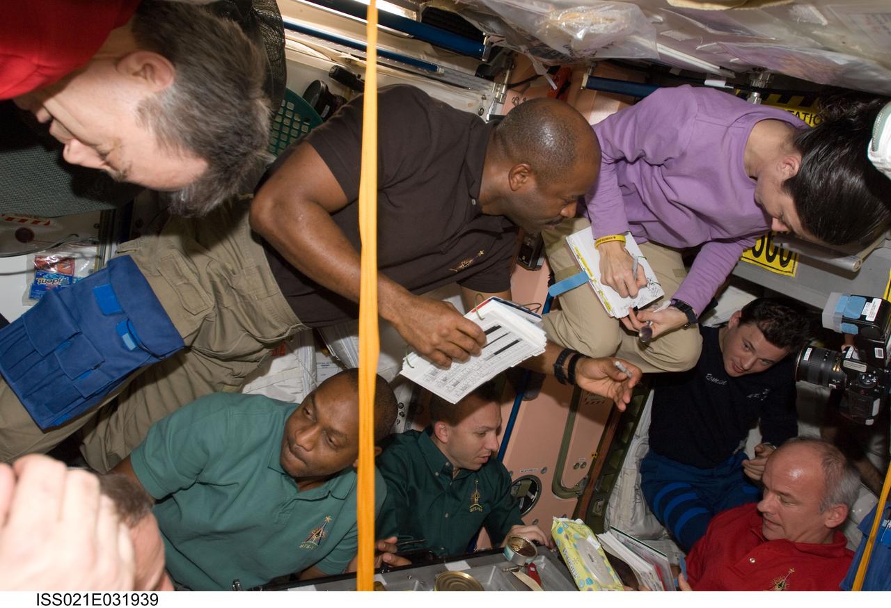 ISS021-E-031939 (23 Nov. 2009) --- Expedition 21 and STS-129 crew members gather for a meal at the galley in the Unity node of the International Space Station while space shuttle Atlantis remains docked with the station. Pictured are Leland Melvin, Robert L. Satcher Jr., Randy Bresnik and Nicole Stott, all STS-129 mission specialists; along with NASA astronaut Jeffrey Williams, Canadian Space Agency astronaut Robert Thirsk and Russian cosmonaut Roman Romanenko, all Expedition 21 flight engineers.