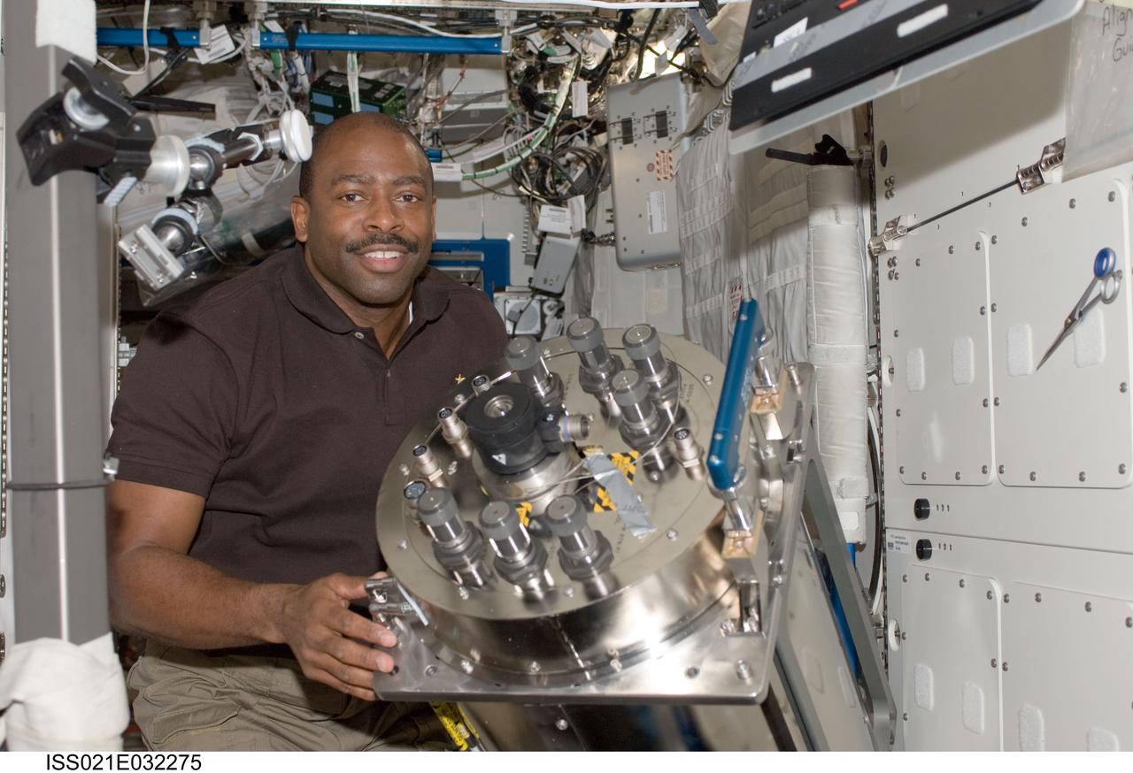 ISS021-E-032275 (23 Nov. 2009) --- NASA astronaut Leland Melvin, STS-129 mission specialist, holds the failed Urine Processor Assembly / Distillation Assembly (UPA DA) in the Destiny laboratory of the International Space Station while space shuttle Atlantis remains docked with the station. Melvin and European Space Agency astronaut Frank De Winne (out of frame), Expedition 21 commander, removed and packed the UPA DA, then transferred it from the Water Recovery System 2 (WRS-2) rack to Atlantis for stowage on the middeck.