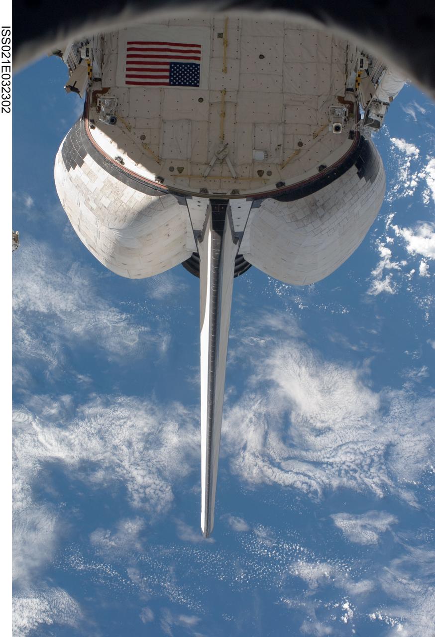ISS021-E-032302 (23 Nov. 2009) --- Backdropped by a blue and white part of Earth, the aft section of the docked space shuttle Atlantis (STS-129) is featured in this image photographed by a crew member on the International Space Station.