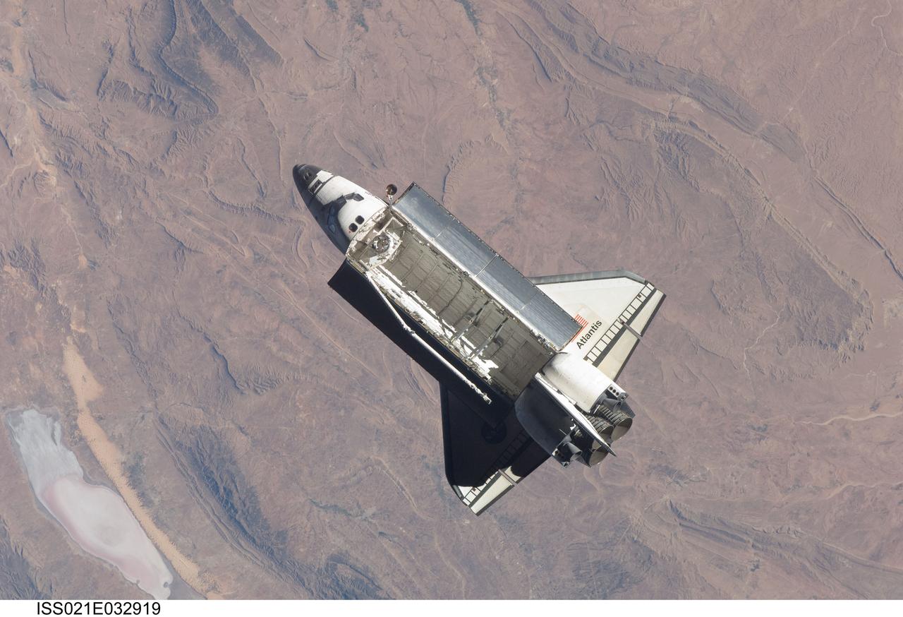 ISS021-E-032919 (25 Nov. 2009) --- Backdropped by rugged Earth terrain, space shuttle Atlantis (STS-129) is featured in this image photographed by an Expedition 21 crew member on the International Space Station soon after the shuttle and station began their post-undocking relative separation. Undocking of the two spacecraft occurred at 3:53 a.m. (CST) on Nov. 25, 2009.