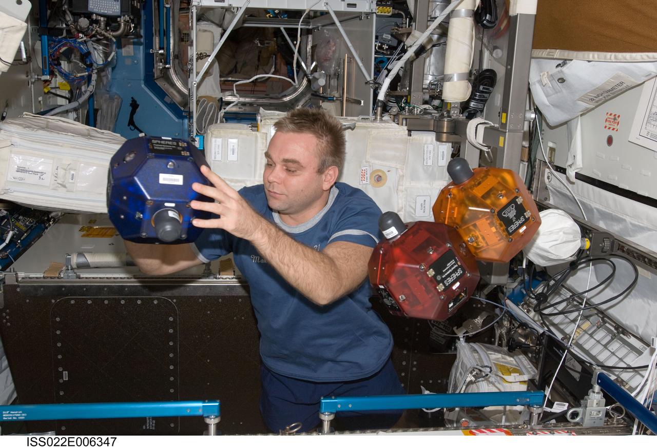 ISS022-E-006347 (5 Dec. 2009) --- Russian cosmonaut Maxim Suraev, Expedition 22 flight engineer, performs a check of the Synchronized Position Hold, Engage, Reorient, Experimental Satellites (SPHERES) Beacon / Beacon Tester in the Destiny laboratory of the International Space Station.