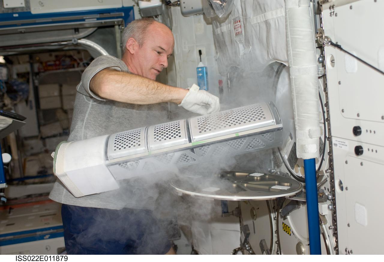 ISS022-E-011879 (16 Dec. 2009) --- NASA astronaut Jeffrey Williams, Expedition 22 commander, services the Advanced Plant Experiments on Orbit-Cambium (APEX-C) payload in the Minus Eighty Laboratory Freezer for ISS-2 (MELFI-2) in the Destiny laboratory of the International Space Station.