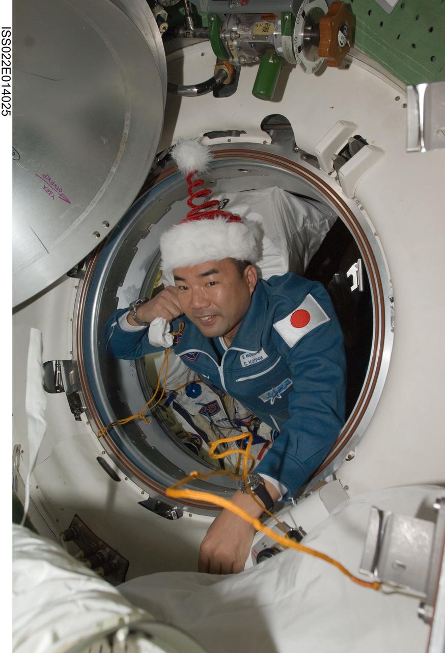 ISS022-E-014025 (22 Dec. 2009) --- Wearing a festive holiday hat, Japan Aerospace Exploration Agency astronaut Soichi Noguchi, Expedition 22 flight engineer, ingresses the International Space Station after arriving onboard a Soyuz TMA-17 with NASA astronaut T.J. Creamer (out of frame) and Russian cosmonaut Oleg Kotov (out of frame), both flight engineers. The crew members launched from the Baikonur Cosmodrome in Kazakhstan 3:52 p.m. (CST) on Dec. 20, 2009, and docked to the station at 4:48 p.m. on Dec. 22.