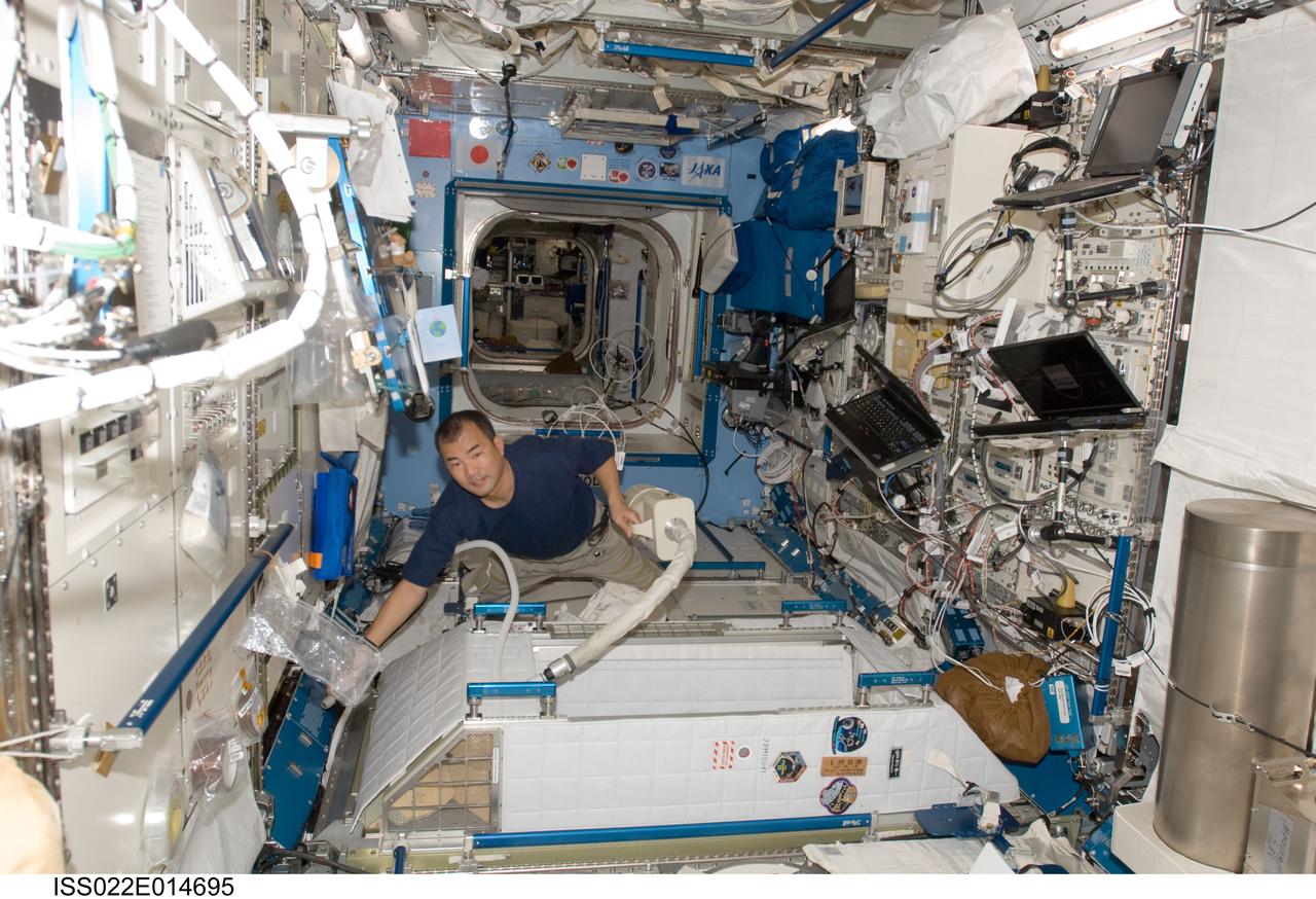 ISS022-E-014695 (26 Dec. 2009) --- Japan Aerospace Exploration Agency astronaut Soichi Noguchi, Expedition 22 flight engineer, uses a vacuum cleaner during housekeeping operations in the Kibo laboratory of the International Space Station.