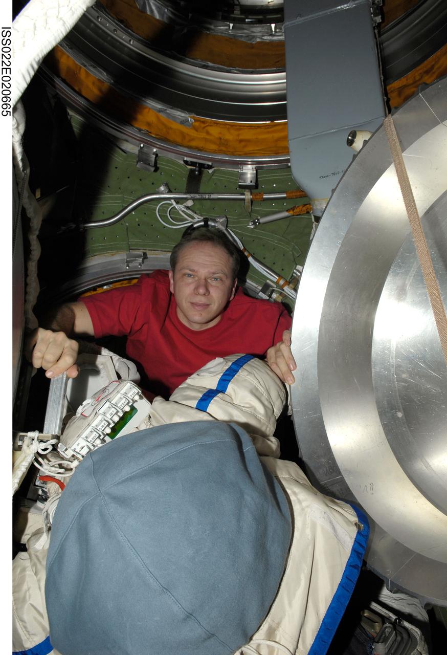 ISS022-E-020665 (7 Jan. 2010) --- Russian cosmonaut Oleg Kotov, Expedition 22 flight engineer, works with extravehicular activity (EVA) equipment in the Pirs Docking Compartment of the International Space Station.