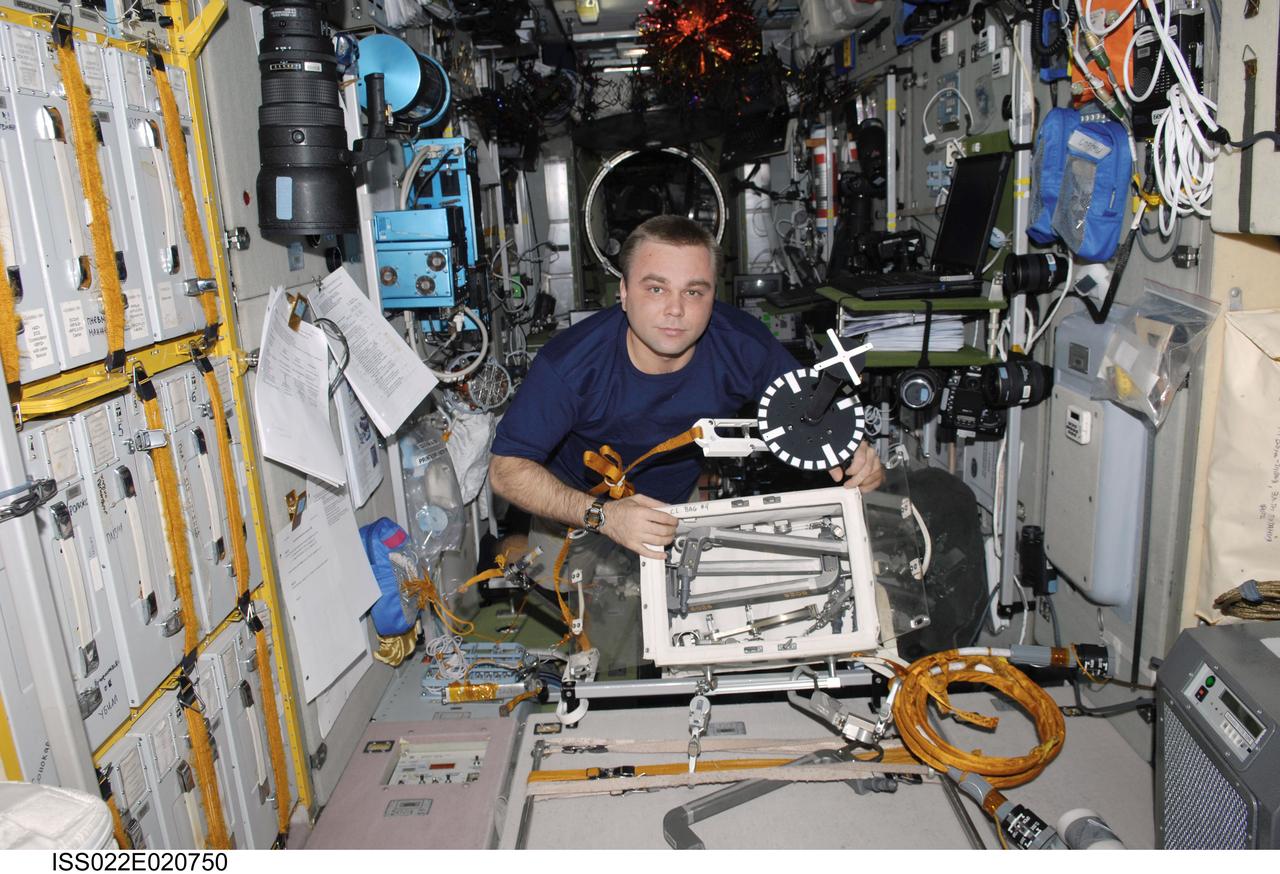 ISS022-E-020750 (6 Jan. 2010) --- Russian cosmonaut Maxim Suraev, Expedition 22 flight engineer, works with extravehicular activity (EVA) equipment in the Zvezda Service Module of the International Space Station.